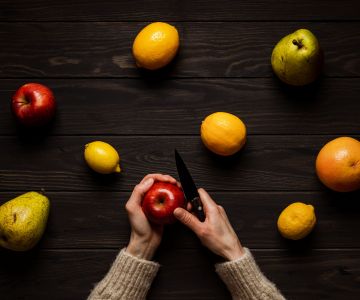 persona che taglia frutta e verdura col coltello