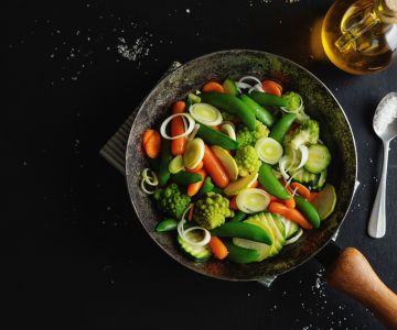 padella con all'interno verdura che sta cuocendo