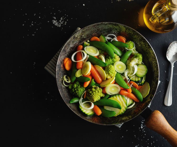 padella con all'interno verdura che sta cuocendo