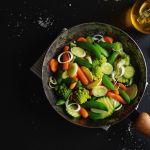 padella con all'interno verdura che sta cuocendo