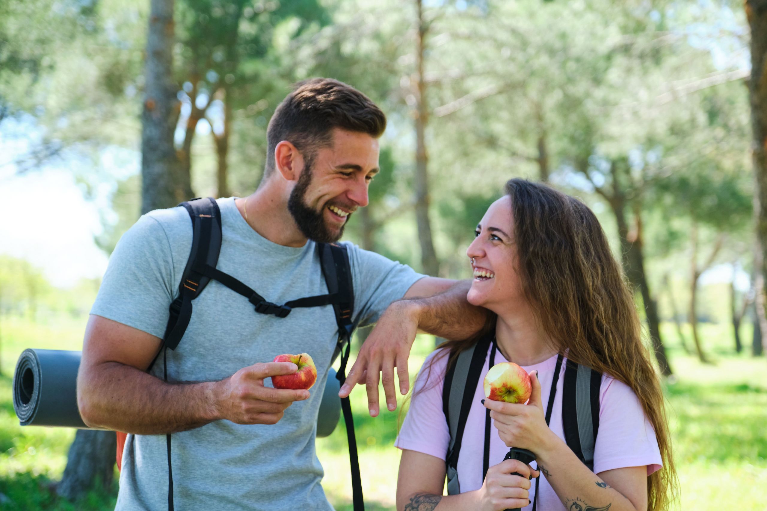 Coppia che mangia una mela mentre fa trekking in montagna