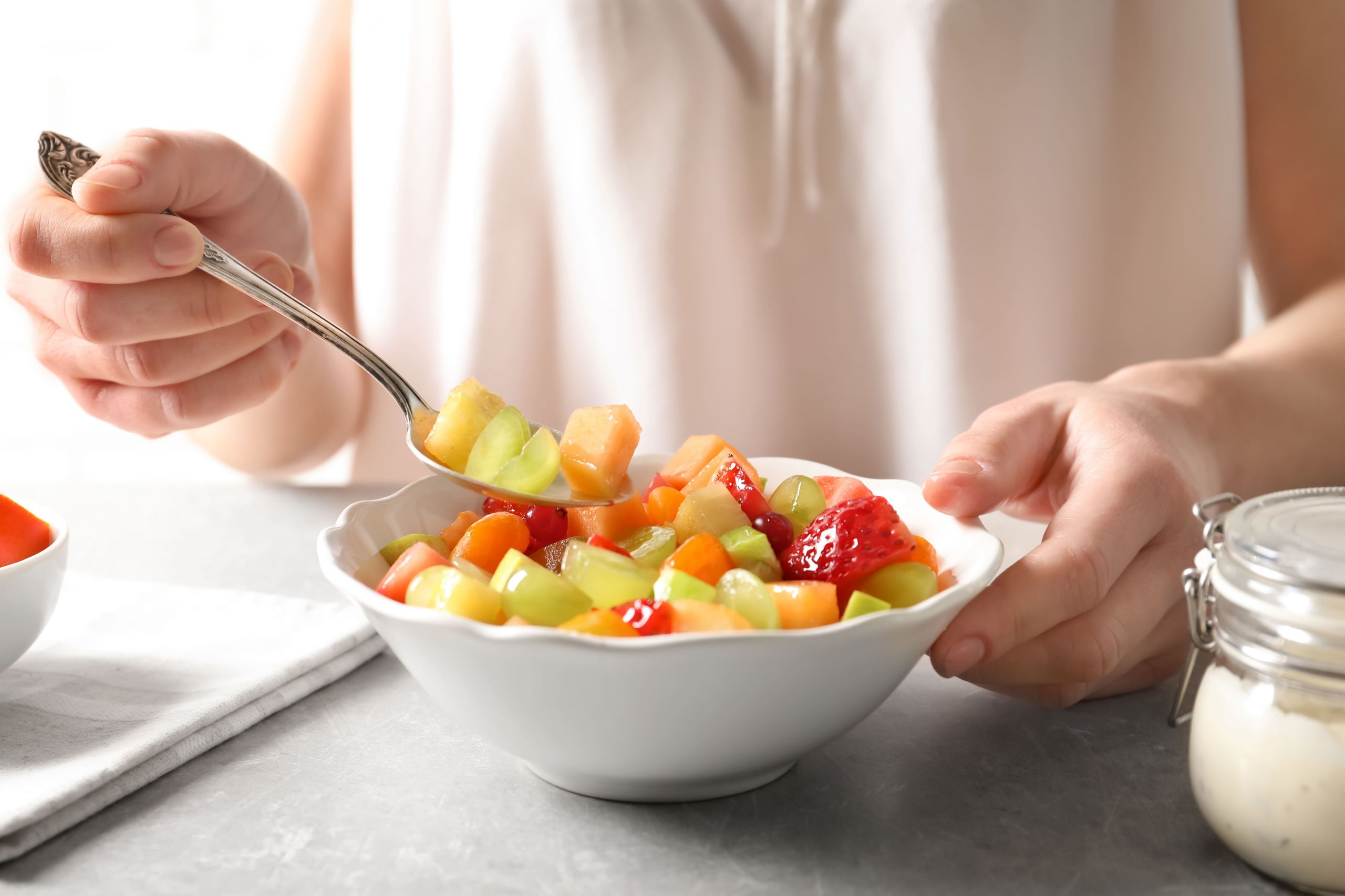 Persona che mangia una macedonia di frutta